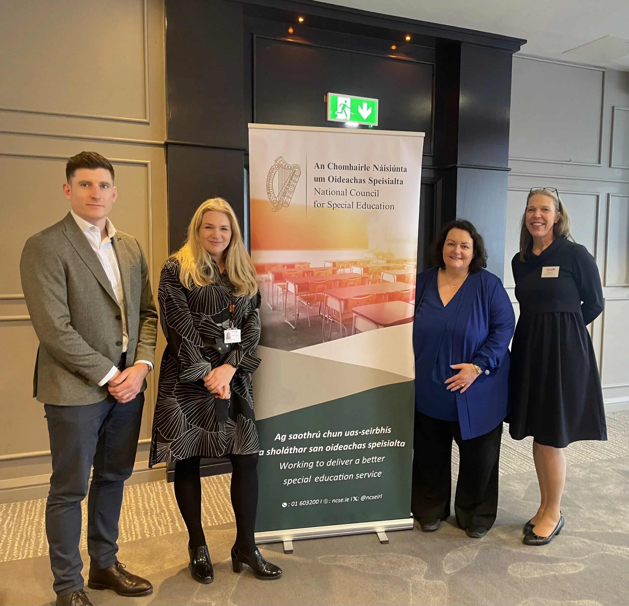 Group of four people standing next to a banner for the National Council for Special Education