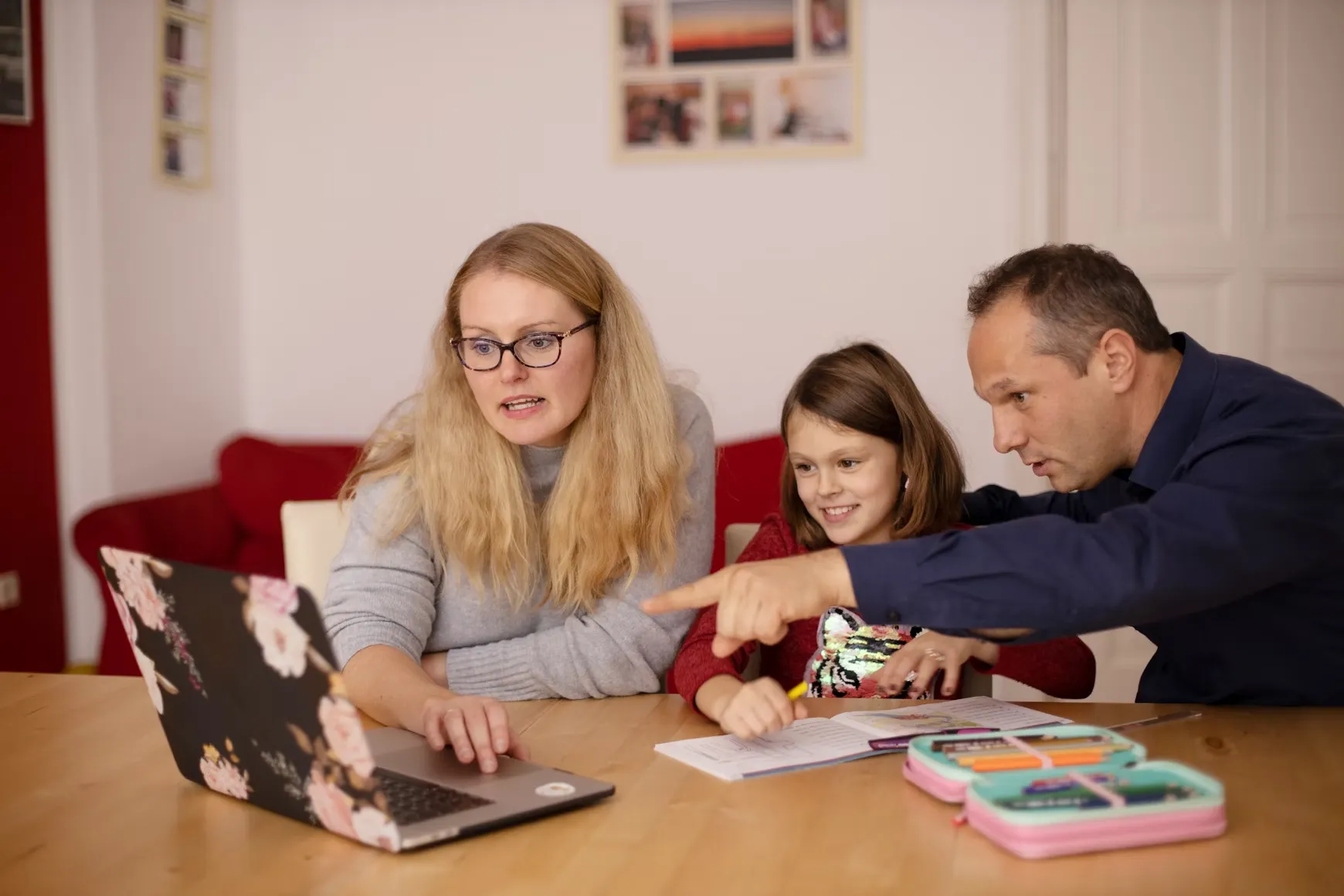 A family working together on a laptop and papers at a table