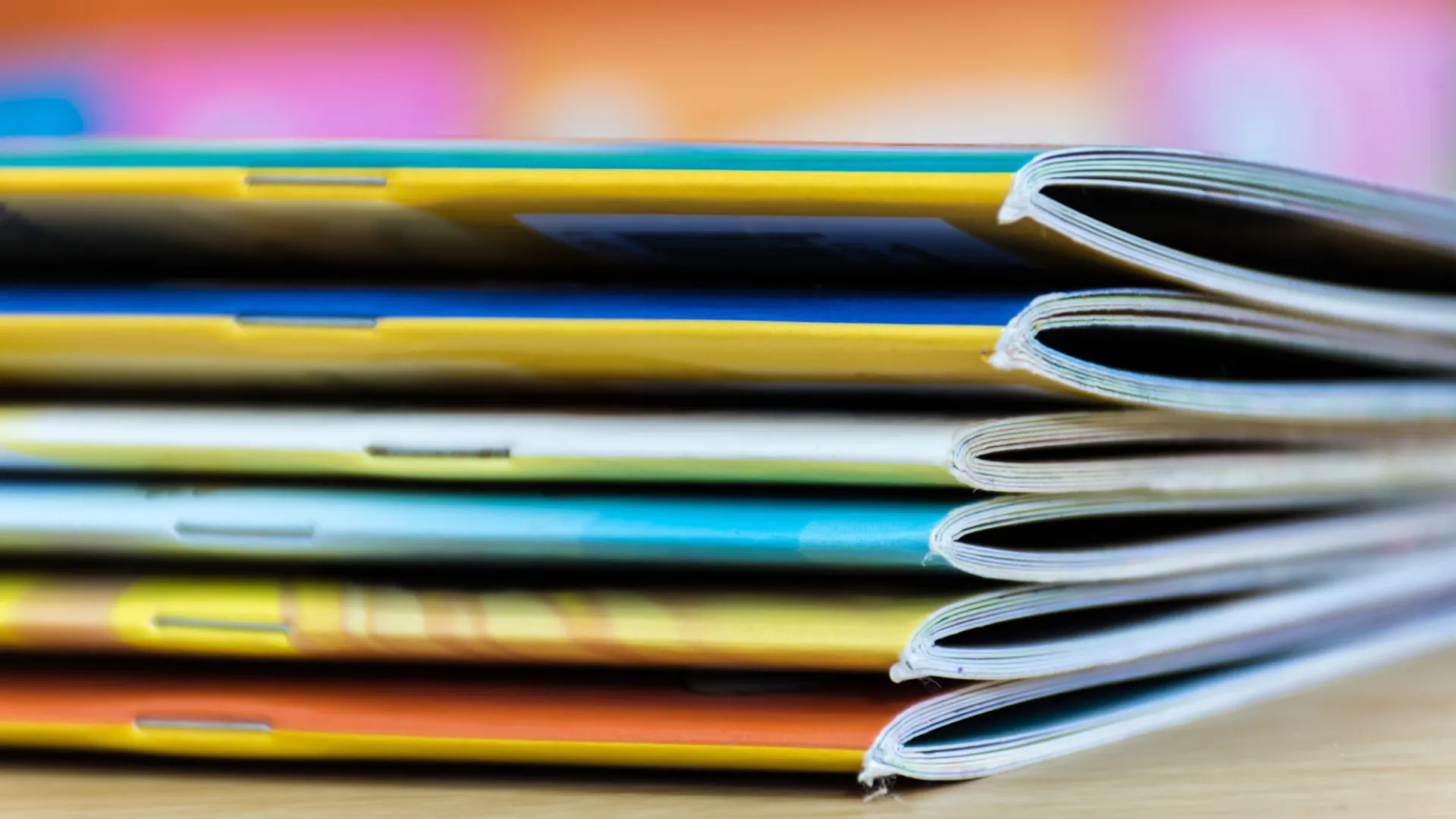 A stack of colourful books placed on a flat surface
