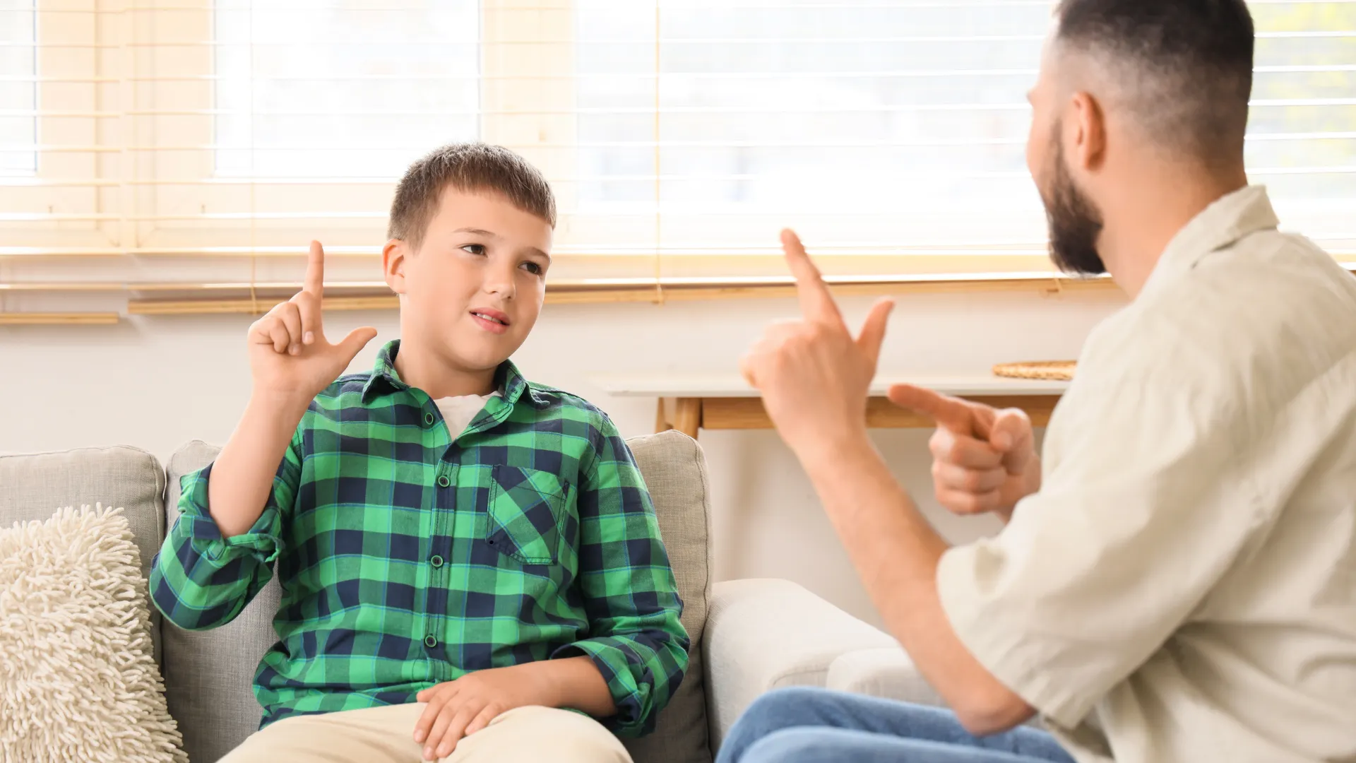 Two people communicating using sign language in a home school setting