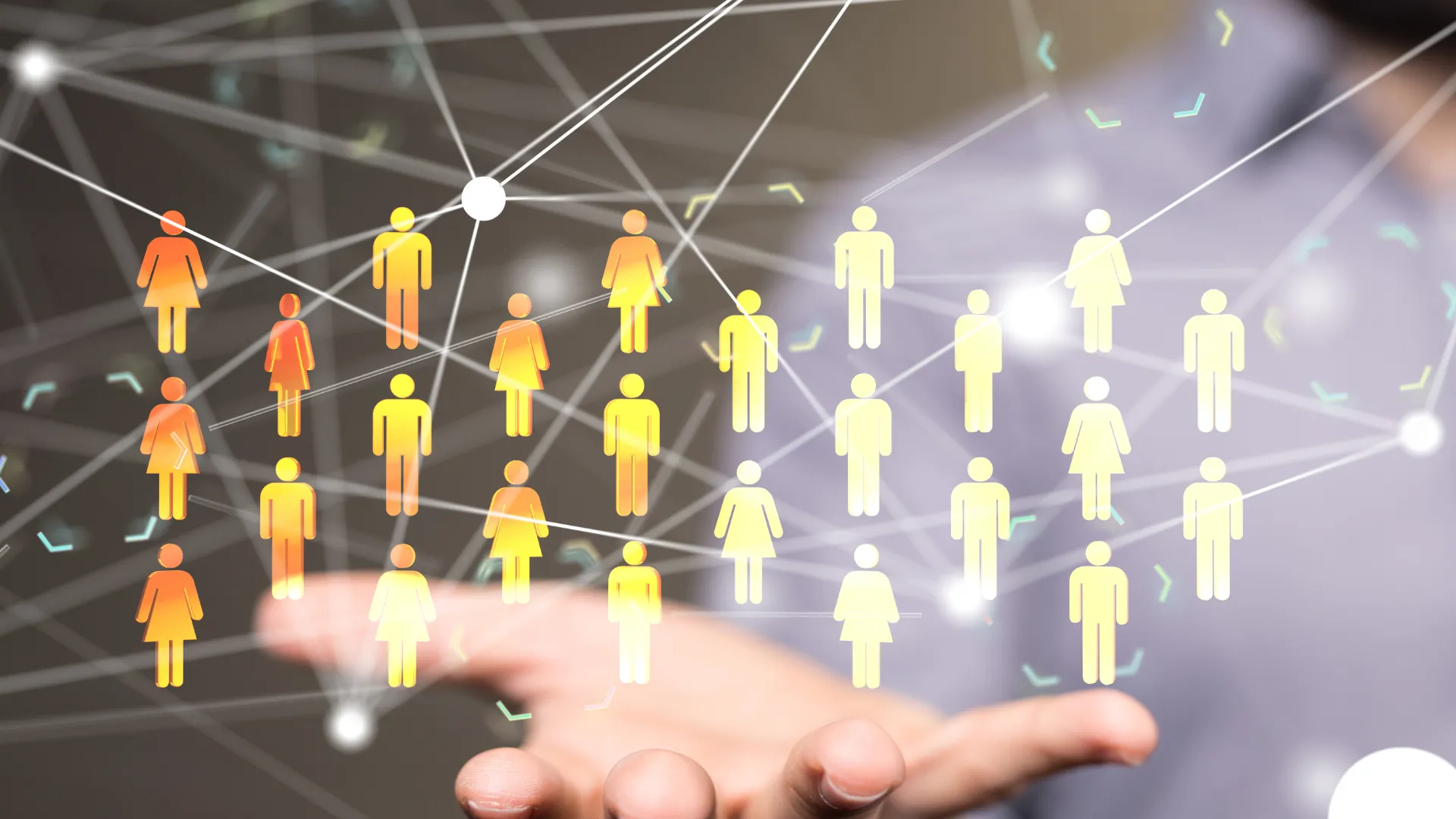 A hand holding a network of interconnected figures representing people.