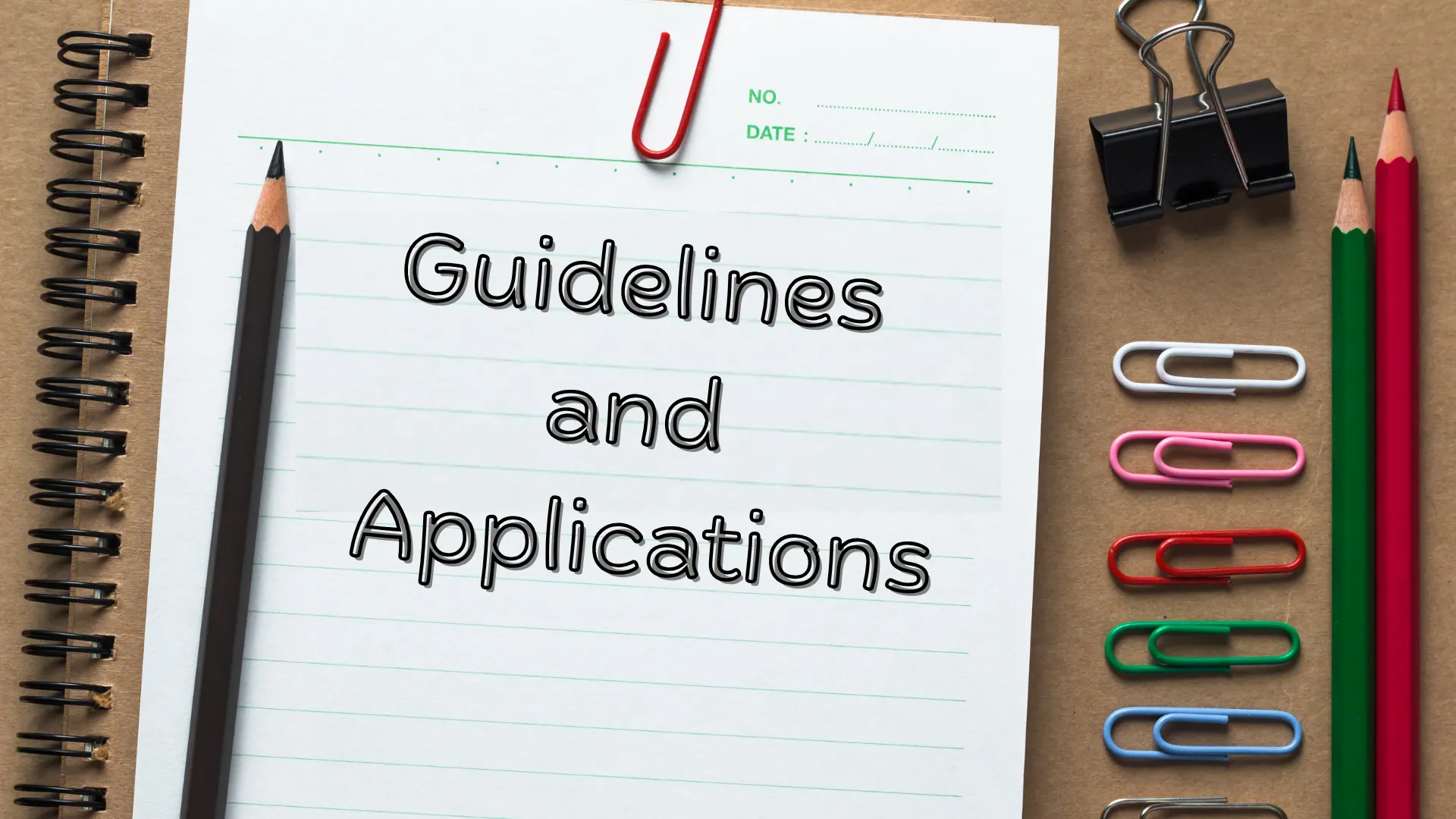 Notebook with the text "Guidelines and Applications" surrounded by stationery items