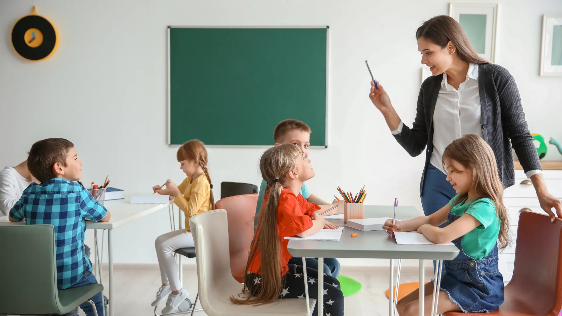 A teacher instructing a small group of young children in a classroom