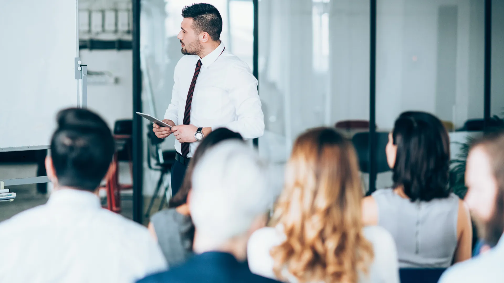 A person giving a presentation to an audience in a professional setting.