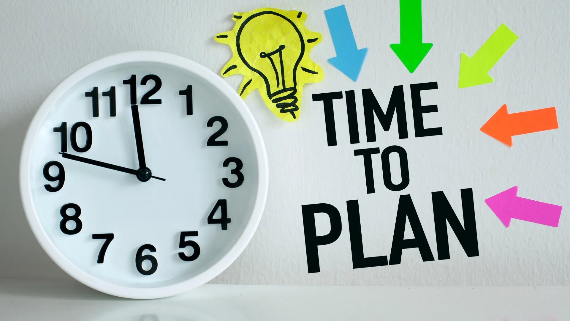 Clock showing 10:10 with the phrase "TIME TO PLAN" a lightbulb and colourful arrows