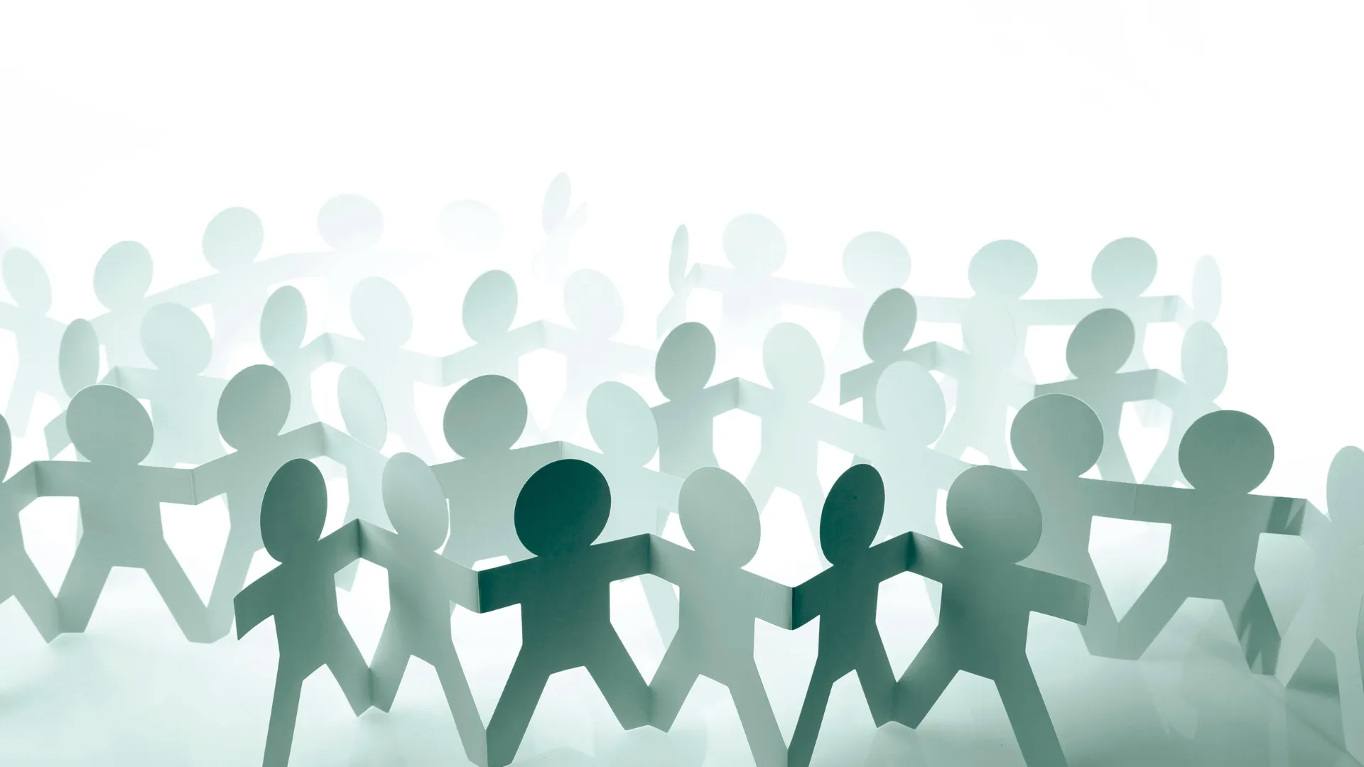 Paper cut-out figures holding hands.