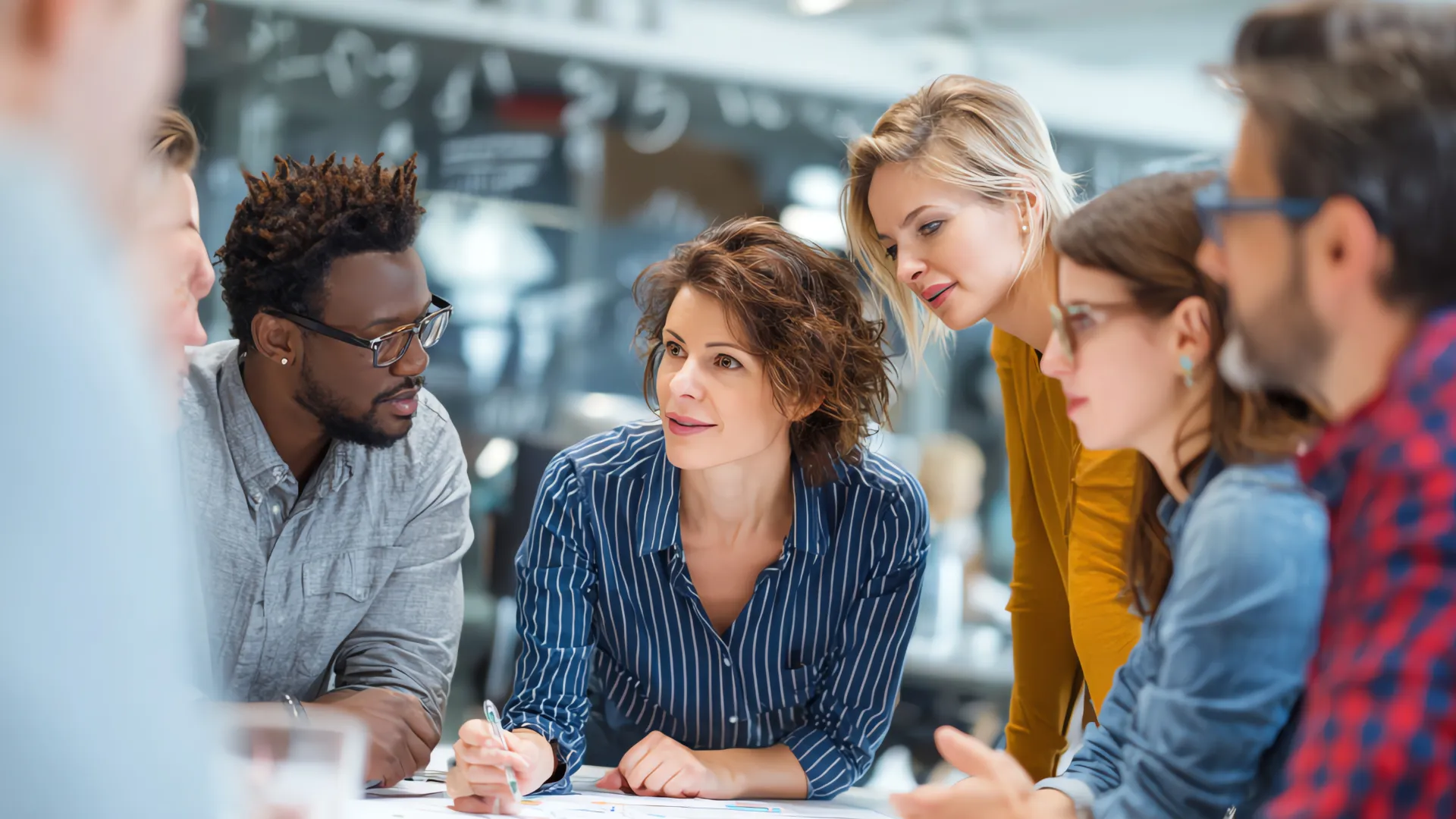 A group of people gathered around a table, collaborating in a office setting