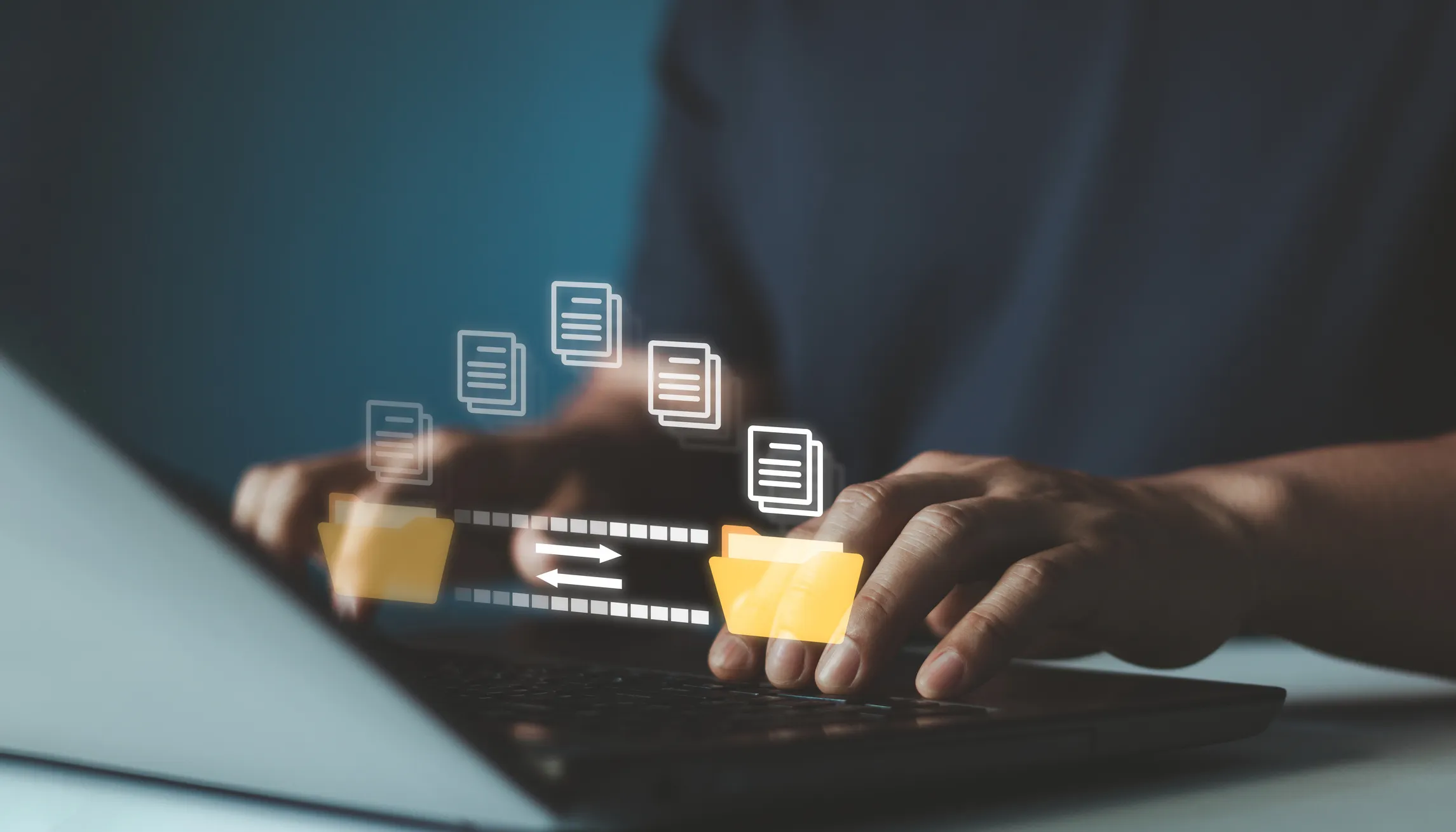 A person types on a laptop keyboard while illustrated digital folders and document icons appear above the keyboard, representing file transfer.