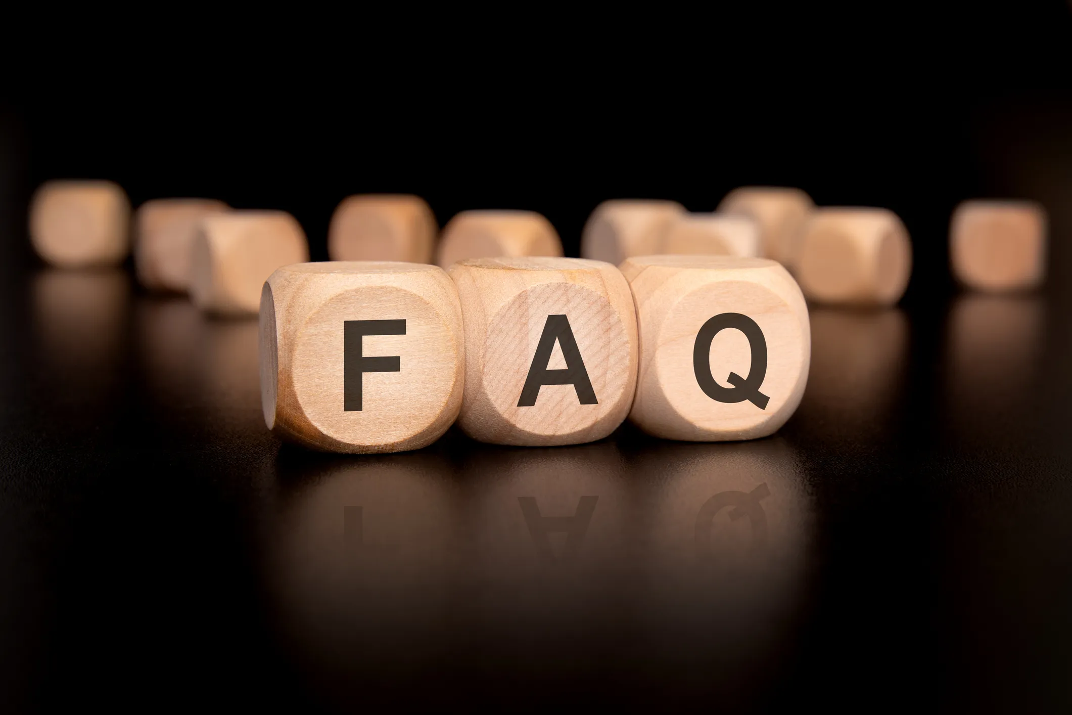 Wooden blocks with the letters FAQ on a dark background