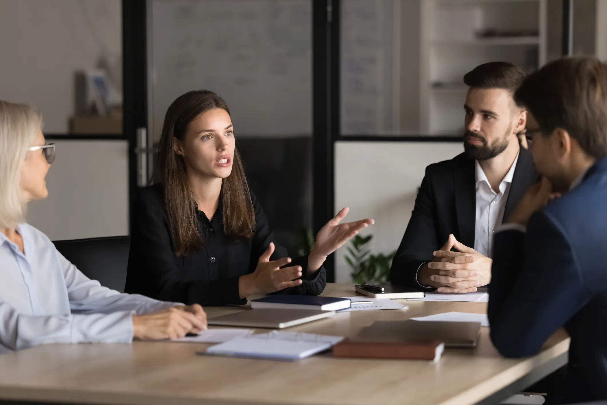 People sitting at a table in a meeting room, engaged in discussion